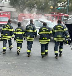 four fire fighters walking in the parking lot