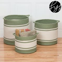 three green and white baskets sitting on top of a wooden floor