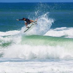 a man riding a wave on top of a surfboard