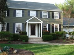 a green house with white trim and black shutters