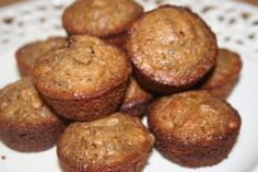 a white plate topped with muffins covered in powdered sugar and brown sugar