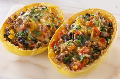 two stuffed bell peppers on a cutting board