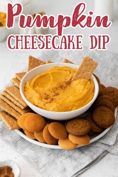 pumpkin cheesecake dip in a white bowl surrounded by crackers and cookies on a plate