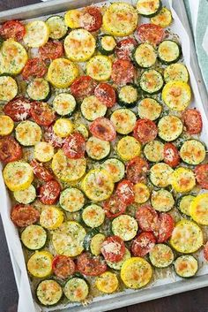 a tray filled with sliced up tomatoes and zucchini