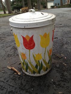 a trash can painted with flowers on it