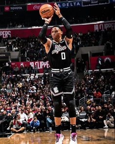 the basketball player is getting ready to dunk the ball in front of an audience