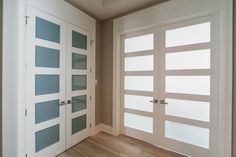 an empty room with glass doors and wood flooring on either side of the door