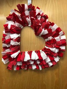 a red and white wreath with polka dots on the front is hanging on a door