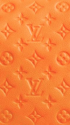 an orange louis vuitton wallet with monograms on the front and side