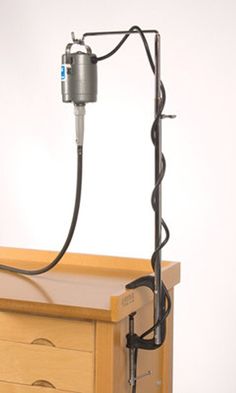 a wooden dresser with a light on top of it and a cord attached to the handle