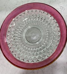 a pink glass bowl sitting on top of a table