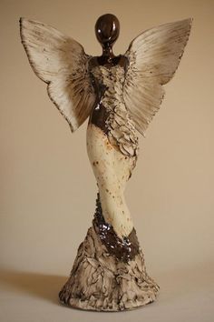 an angel figurine made out of wood and clay