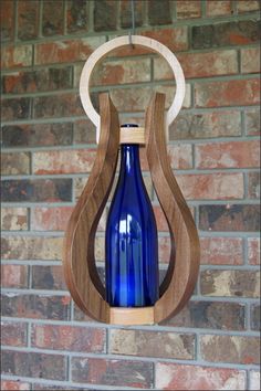 a blue glass bottle hanging from a wooden holder