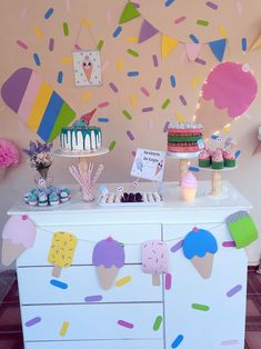 an ice cream shop with colorful decorations and desserts on the buffet table in front of it