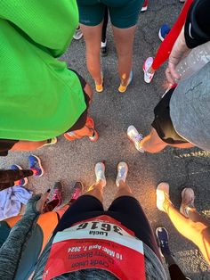 several people standing in a circle with their feet on the ground and one person wearing running shoes