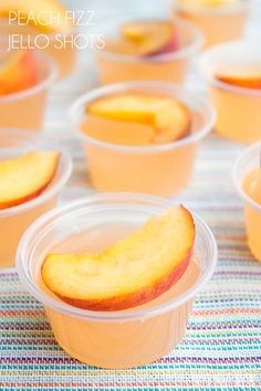 peach fizz jello shots in plastic cups on a colorful tablecloth with text overlay