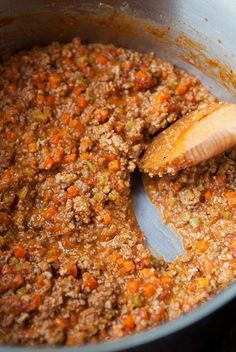 a wooden spoon mixing food in a pot