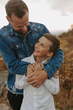 a man holding a little boy in his arms