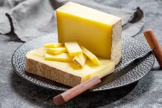 a piece of cheese is on a plate with bread