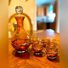 a glass decanter and four glasses on a table