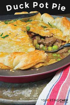 a close up of a pie on a plate with a fork in it and the words duck pot pie