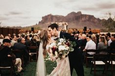 a bride and groom kissing in front of an outdoor ceremony