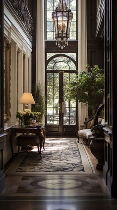 a hallway with a chandelier hanging from the ceiling next to an entrance way