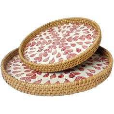 two round wicker trays with red and white designs on the bottom one is holding a plate