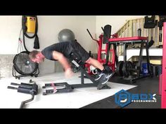 a man doing a trick on a skateboard in a garage with other equipment around him