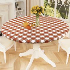 a table with a checkered cloth on it and flowers in a vase at the top