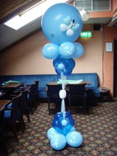 blue balloons are floating in the air at a party or function room with tables and chairs