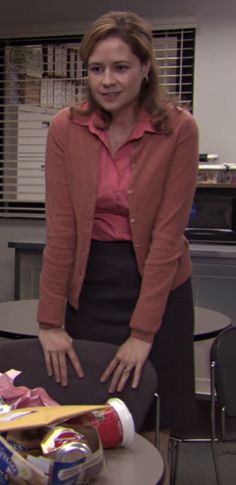 a woman standing next to a table with food on it