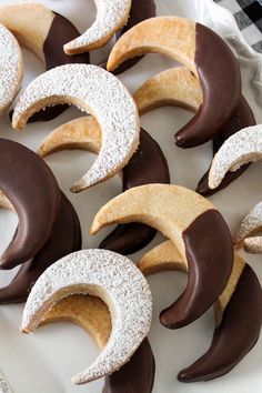 cookies with chocolate and powdered sugar in crescent shapes on a white platter, ready to be eaten