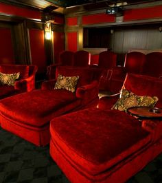 an image of a movie theater with red couches and pillows on the seats that are reclinered