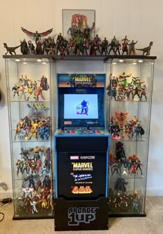 a display case filled with toys and action figures on top of a carpeted floor