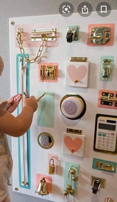 a baby standing in front of a wall covered with magnets