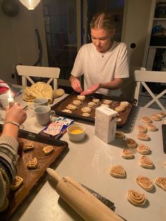 two women are making cookies on a table