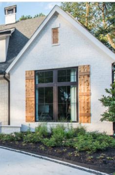 a white house with wooden shutters and windows