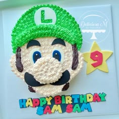 a birthday cake made to look like mario's face with green hat and mustache