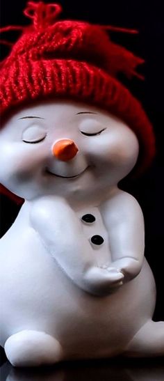 a white snowman with a red hat on