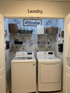 a washer and dryer in a laundry room with wallpaper on the walls