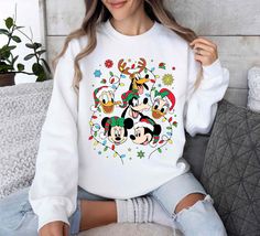 Mickey and Friends Christmas Sweatshirt,Vintage Disneyland Christmas Sweatshirt,Disneyland Sweatshirt,Christmas Family Shirt 🌟 Welcome to Our Shop! 🌟 Please Review All Photos Carefully for Details. 🌟 Select Your T-Shirt Size from the Dropdown Menu Next to the Product Image. 🌟 Choose Your T-Shirt Color from the Options Provided in the Second Picture. 🌟 Customize Your Order by Using the "Add Message to Seller" Link During Checkout. 🌟 Shipping Time Varies Depending on Your Location (We Operat Winter White Mickey Mouse Sweatshirt, Disney White Christmas Tops, Disney Character Print Winter Sweatshirt, Disney Christmas Sweatshirts Women, Vintage Disneyland Sweatshirt, Disneyland Sweatshirt, Disney Christmas Sweatshirts & Hoodies, Disneyland Christmas, Vintage Disneyland