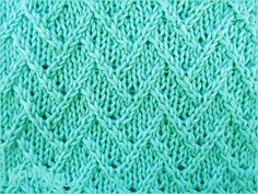 a close up view of the knitting stitchs on a knitted blanket in aqua green