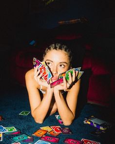 a woman laying on the floor holding up cards