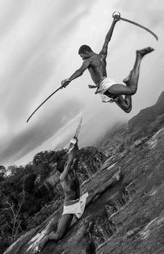 two men are performing acrobatic tricks on the beach