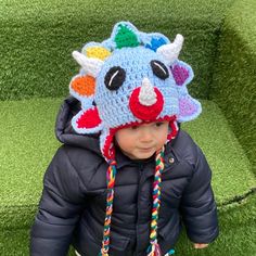 a small child wearing a crocheted hat with horns on it's head