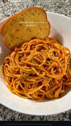 a white bowl filled with spaghetti and bread