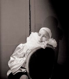 a woman sitting on top of a chair wearing a head scarf