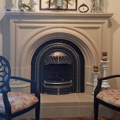 two chairs sitting in front of a fire place