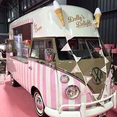 an ice cream truck is parked in a building with pink and white stripes on it